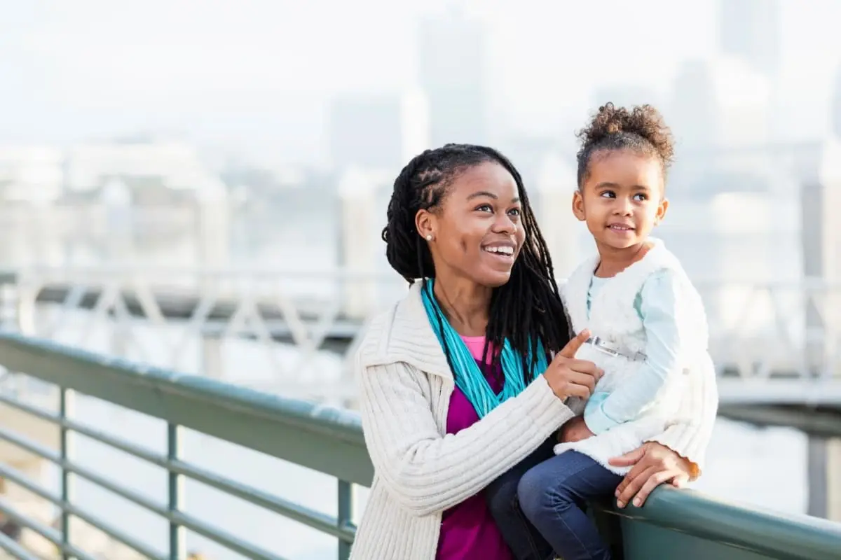 Young mom sits with daughter in a city